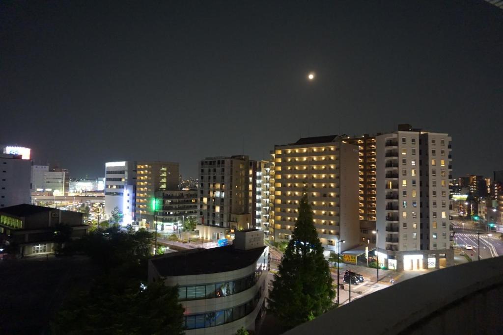 a city at night with the moon in the sky at Duetoir 801 / Vacation STAY 7558 in Nagoya