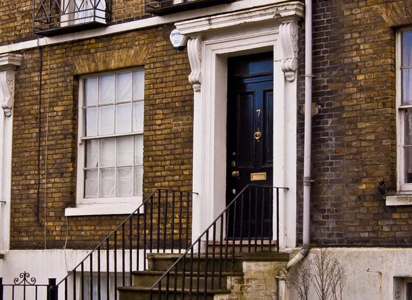 una puerta negra en un edificio de ladrillo con escaleras en No 7 Priory Guest House en Dover