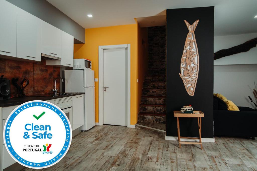 una cocina con una mesa y un cartel que diga limpio y seguro en Casa Janelas da Fonte Nova, en Setúbal