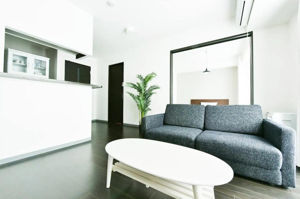 Suncourt Hondori Garden Hills / Vacation STAY 7592 في سابورو: غرفة معيشة بها أريكة وطاولة