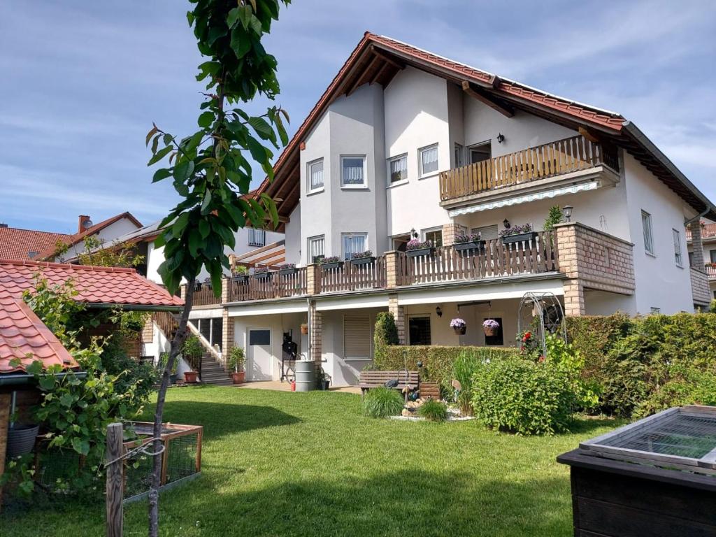 Großes weißes Haus mit Balkon in der Unterkunft Ferienwohnung Kempf Mandelbachtal in Ommersheim