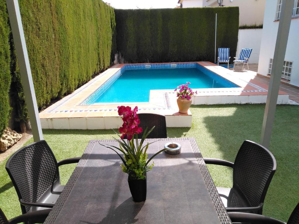 uma mesa e cadeiras num pátio com piscina em 3 bedrooms chalet with private pool furnished terrace and wifi at Cullar Vega em Cúllar-Vega