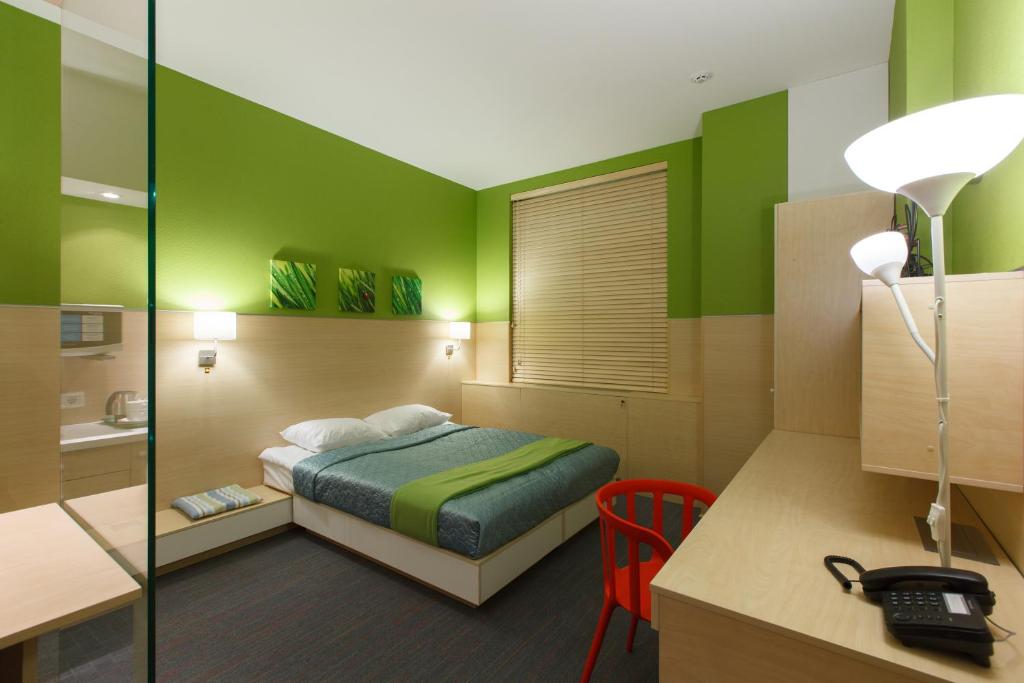 Habitación de hotel con cama y escritorio con ordenador en Sleeport, en Dnipro