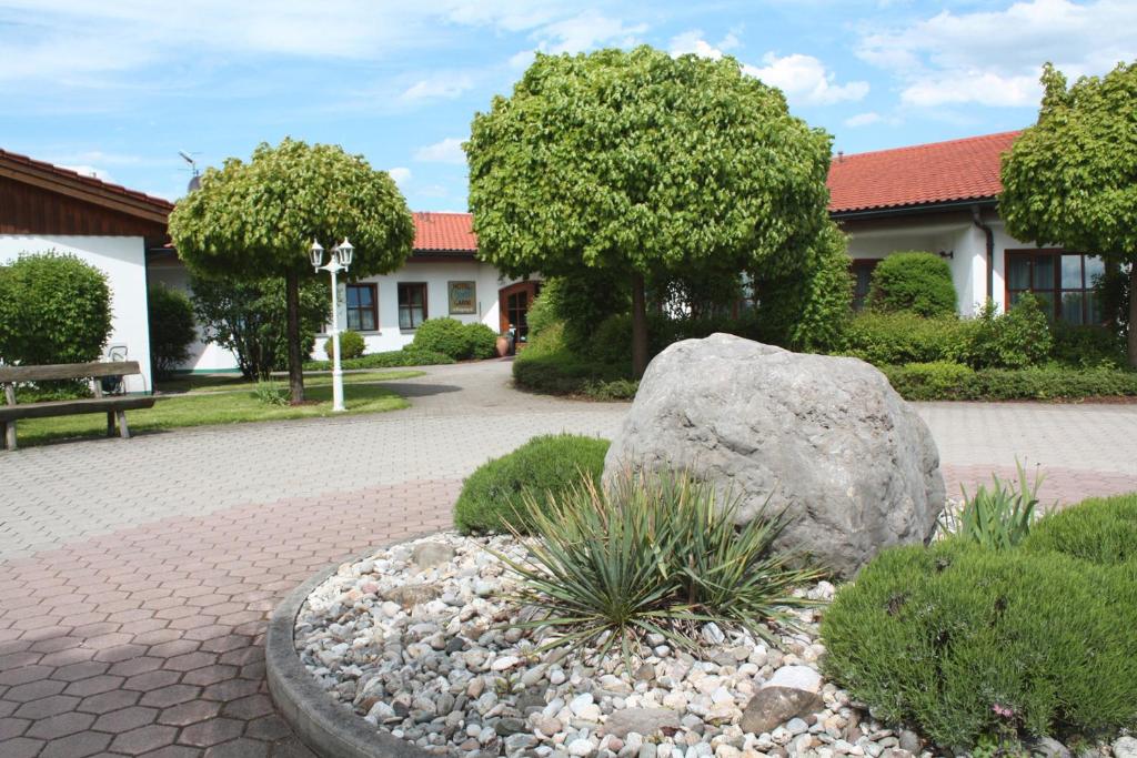 una roca en un jardín frente a un edificio en Hotel Christl, en Rohrdorf