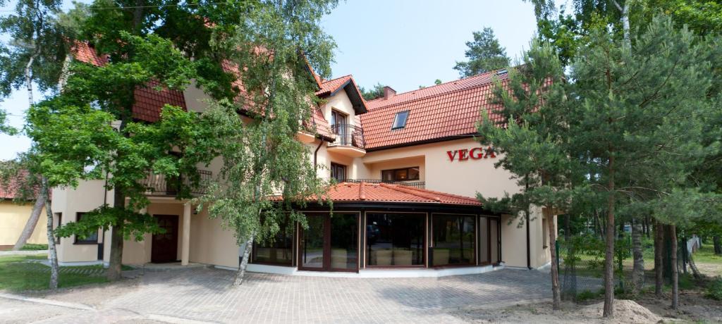 una vista de un edificio con árboles delante de él en Ośrodek Vega, en Pobierowo