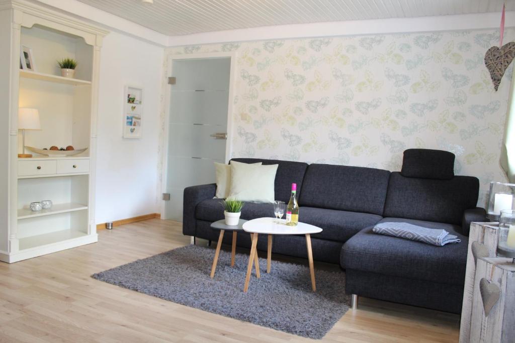 uma sala de estar com um sofá azul e uma mesa em Ferienwohnung Bergluft em Winterberg