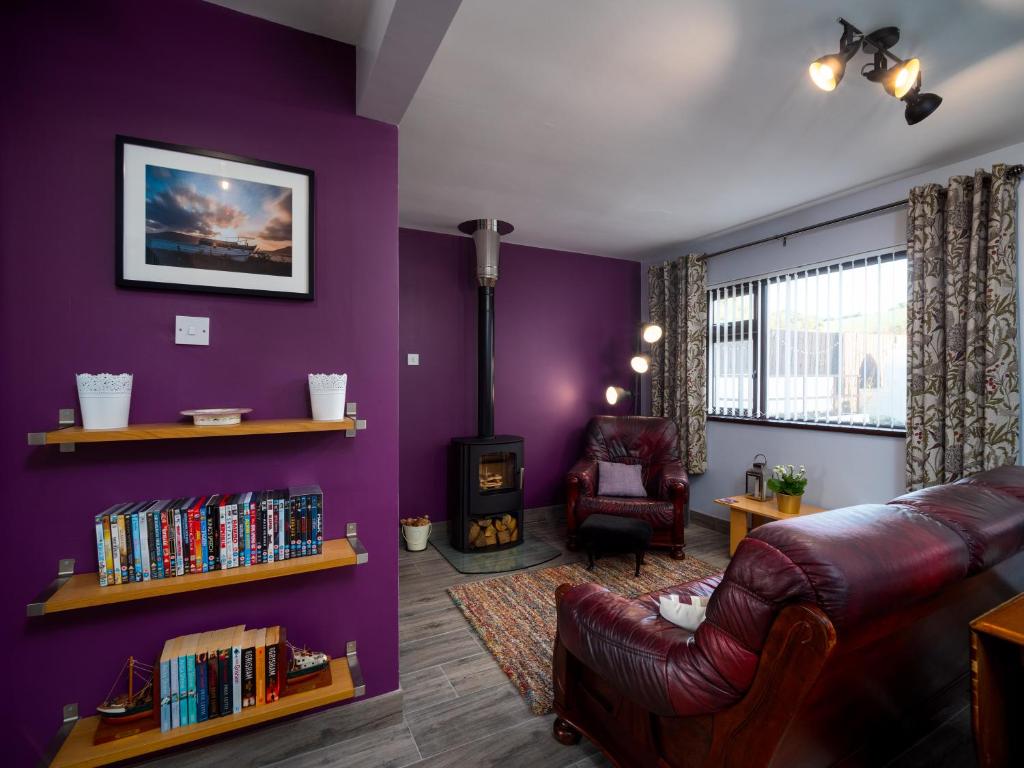 a living room with purple walls and a couch and a chair at A fourteen in Kilkeel