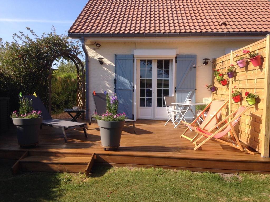 een houten terras met potplanten en een huis bij Nature Et Plage in Audembert