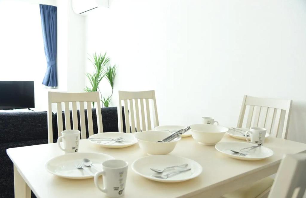 stół z białymi płytami i srebrnymi sztućcami w obiekcie Hills Garden Hondori / Vacation STAY 7586 w mieście Sapporo