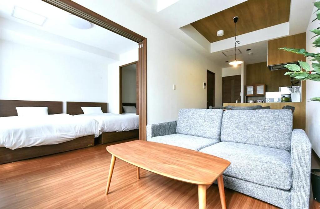 een woonkamer met een bank en een bed bij Hills Garden Hondori / Vacation STAY 7583 in Sapporo