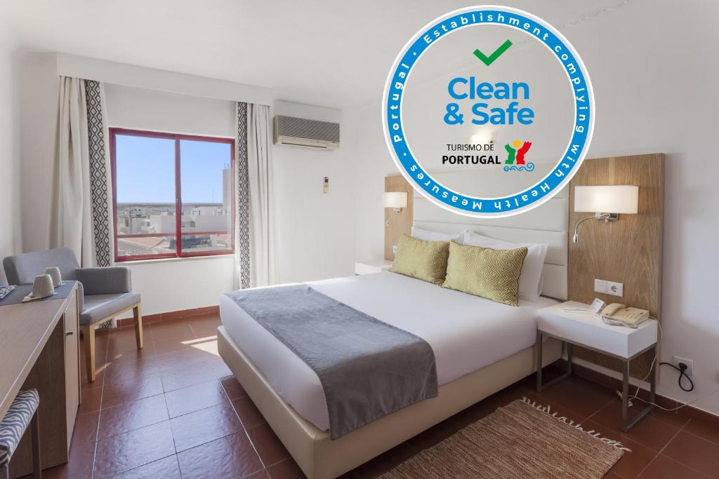 a bedroom with a bed and a desk in a room at Best Western Hotel Dom Bernardo in Faro
