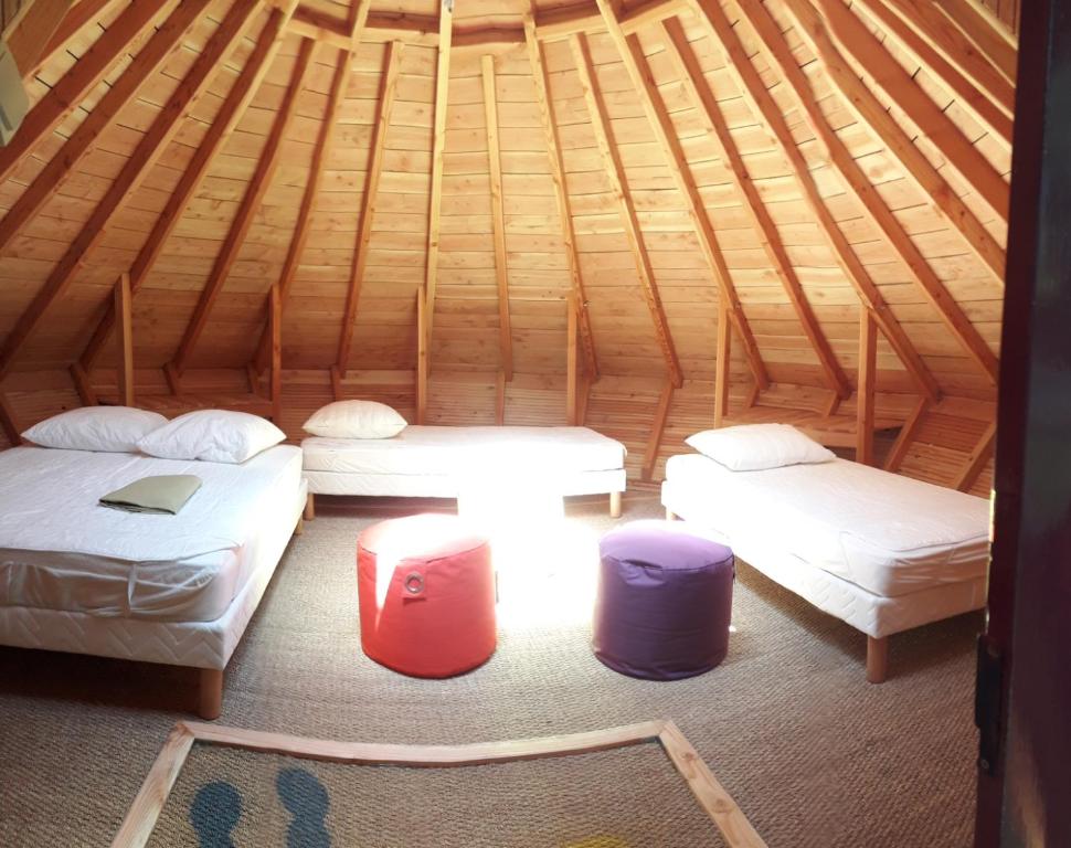 um quarto com 3 camas num iglu de madeira em Tipis Du Petit Buisson em Saint-Antonin-de-Lacalm