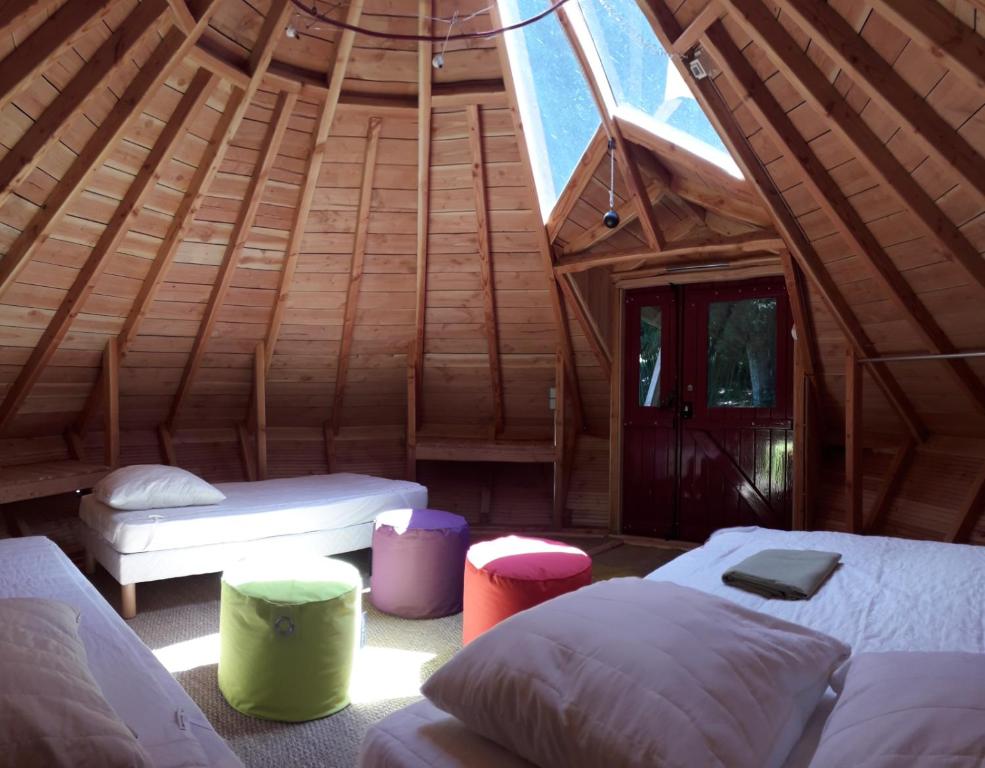 um quarto com 2 camas num chalé de madeira em Tipis Du Petit Buisson em Saint-Antonin-de-Lacalm