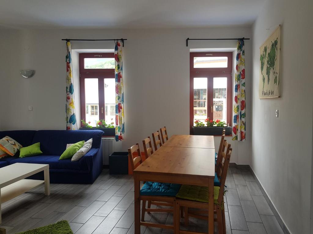un soggiorno con un tavolo e un divano blu di Thirsty River Rooms a Bovec