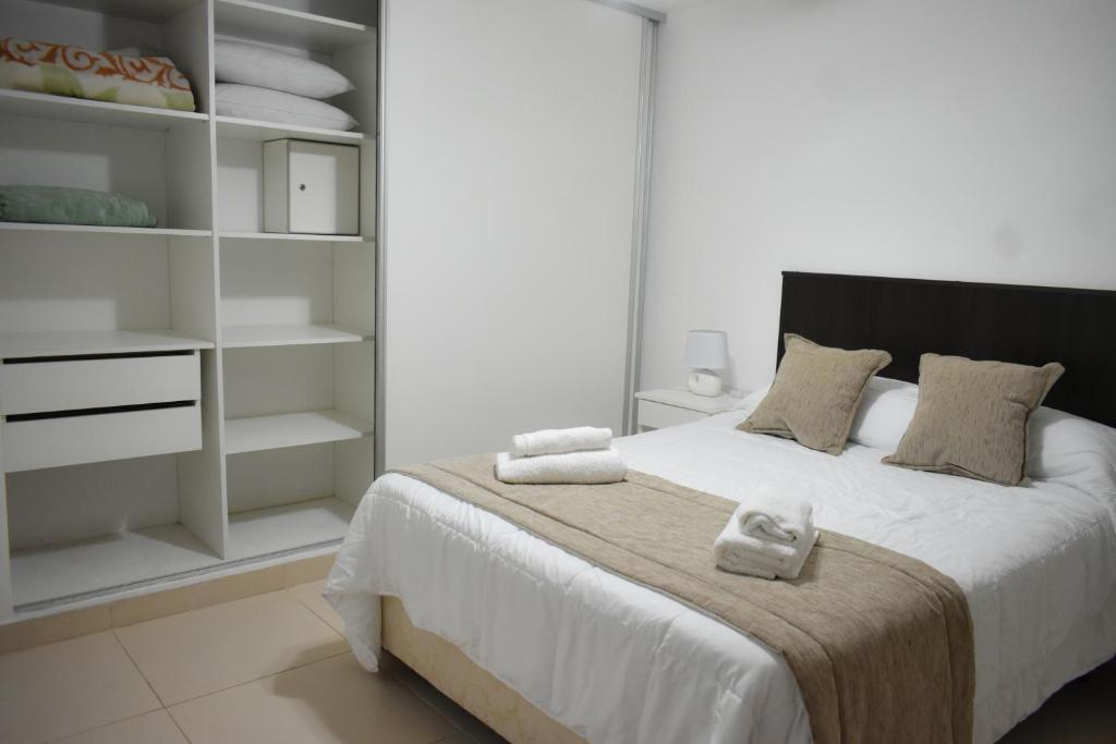 1 dormitorio con 1 cama grande con estanterías blancas en Carol 7 en Salta