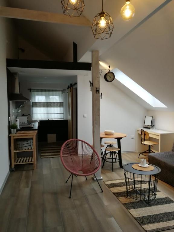 a living room with a red chair and a table at Studio apartman HANA in Drežnik Grad