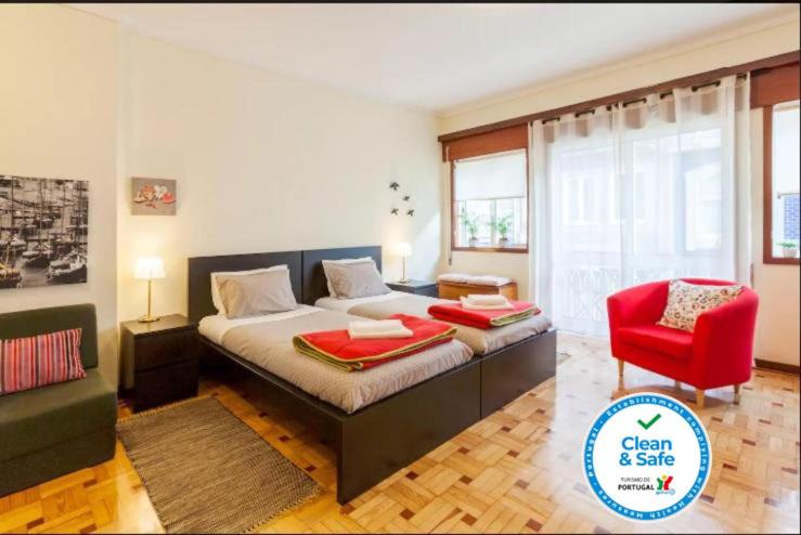 1 dormitorio con 1 cama grande y 1 silla roja en Cozy loft in downtown, en Oporto