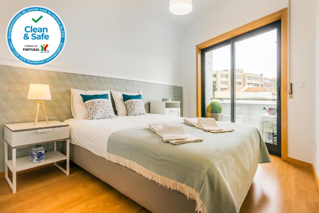 a bedroom with a large bed and a window at Camões Executive Flat in Porto