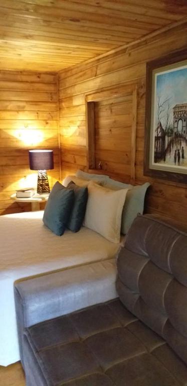 1 dormitorio con 1 cama, 1 lámpara y 1 sofá en Pousada Natureza Serrana, en Urubici
