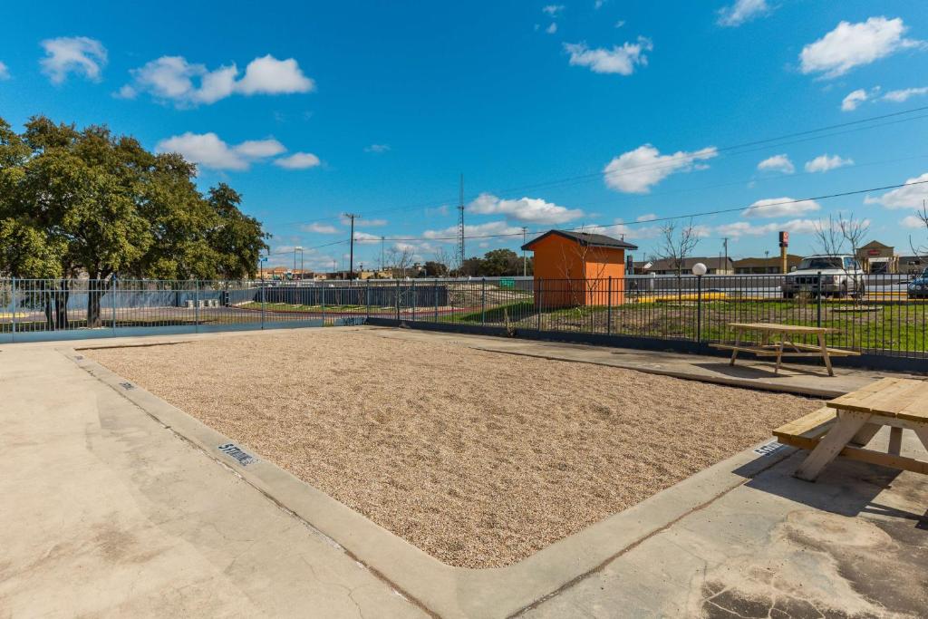 a baseball field with a bench and a fence at Studio 6-Temple, TX in Temple