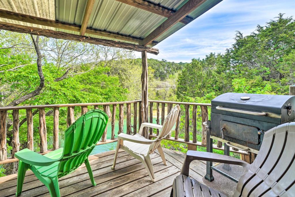 a deck with chairs and a grill on it at Rustic Davis Cabin Less Than half Mile to Turner Falls! in Davis