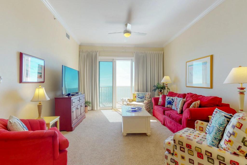 a living room with red couches and a television at Windemere in Perdido Key