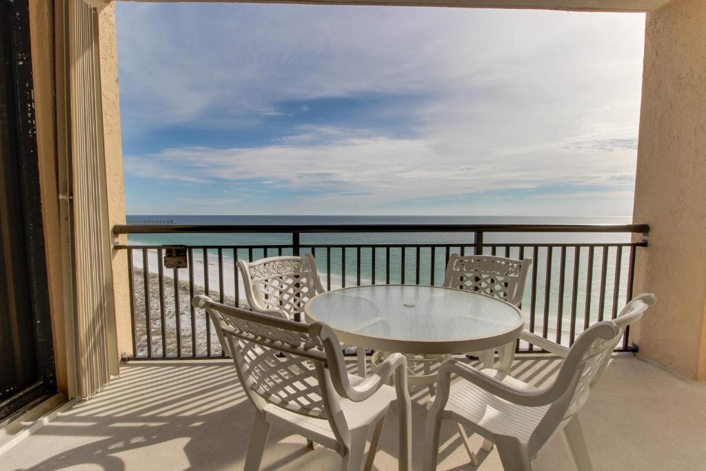 uma mesa e cadeiras numa varanda com vista para o oceano em Navarre Towers Condos em Navarre