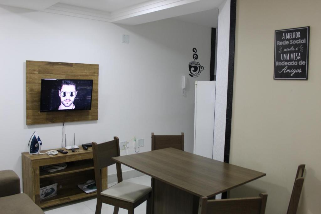 una sala da pranzo con tavolo e sedie in legno di Ap novo a 90m da praia a Guarapari