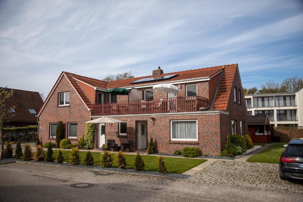 a brick house with a balcony on top of it at Friesenstraße 13 in Bensersiel