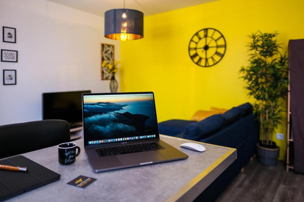 einen Laptop auf einem Tisch im Wohnzimmer in der Unterkunft Le Business House in Saint-Omer
