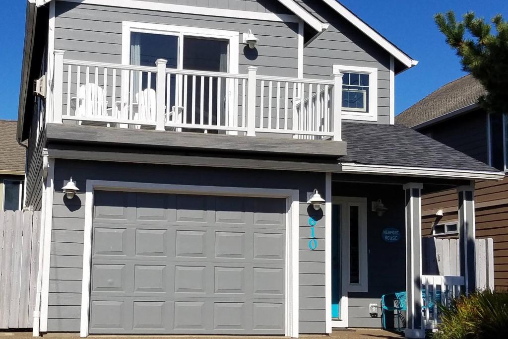 a garage door with a balcony on top of a house at Newport House at Nye Beach in Newport