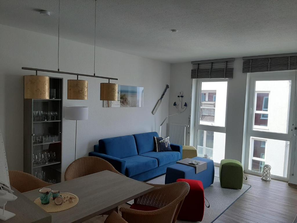 a living room with a blue couch and a table at Residenz Bollwark Port Olpenitz in Kappeln