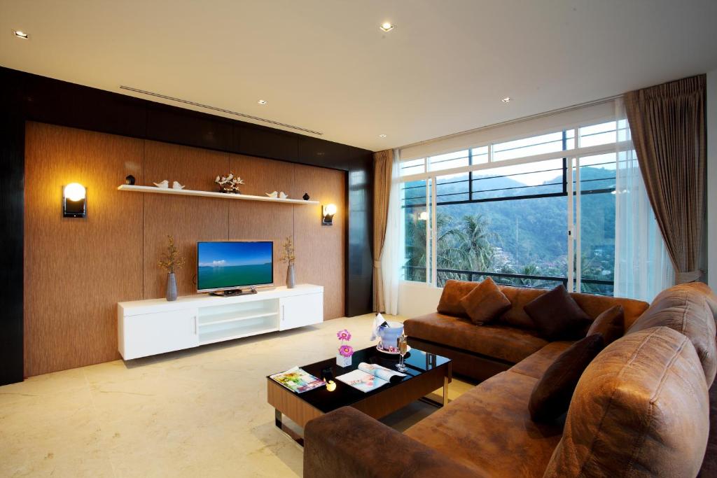ein Wohnzimmer mit Couch und Fernseher in der Unterkunft Kata Sea View Villas in Kata Beach