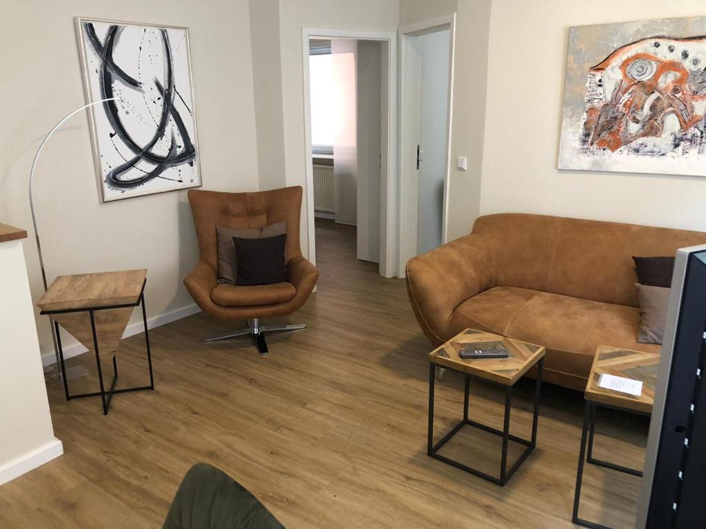 ein Wohnzimmer mit einem Sofa und 2 Stühlen in der Unterkunft Esprit-Apart-Hotel in Baden-Baden