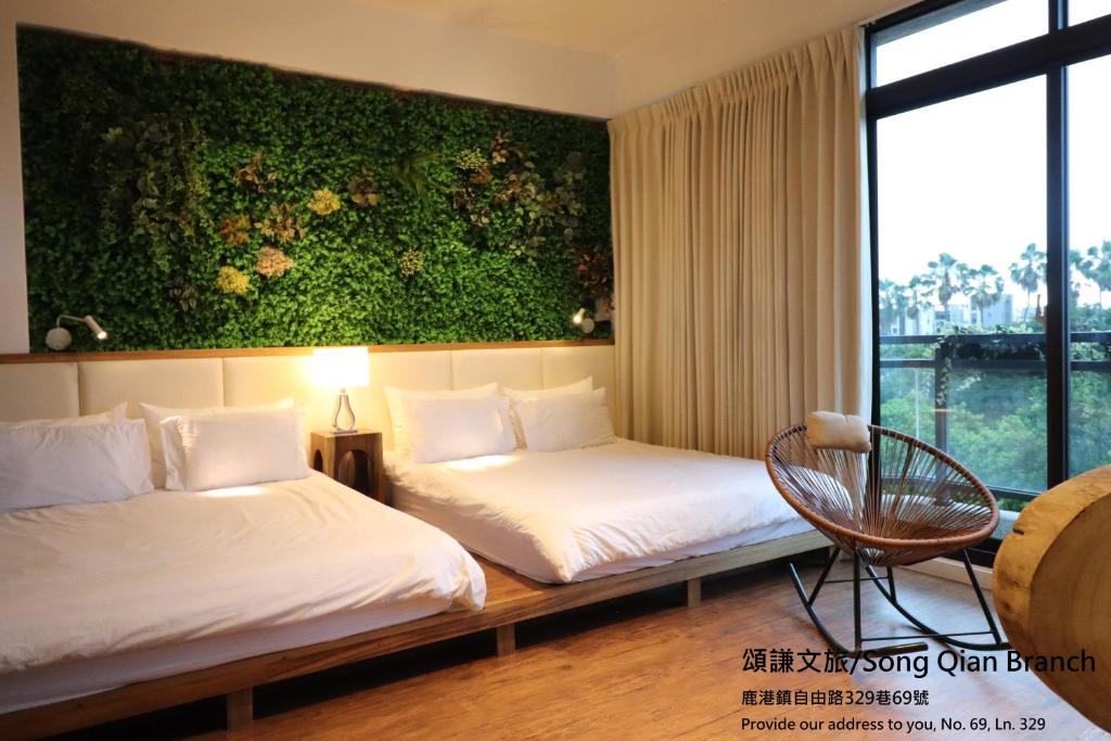 鹿港的住宿－頌謙文旅 梅花鹿同住，酒店客房设有两张床和绿色的墙壁。