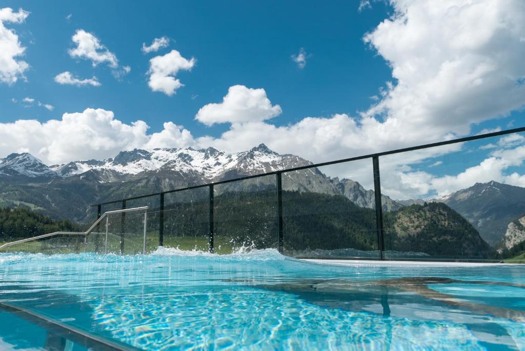 a swimming pool with mountains in the background at Suites by Mein Almhof in Nauders