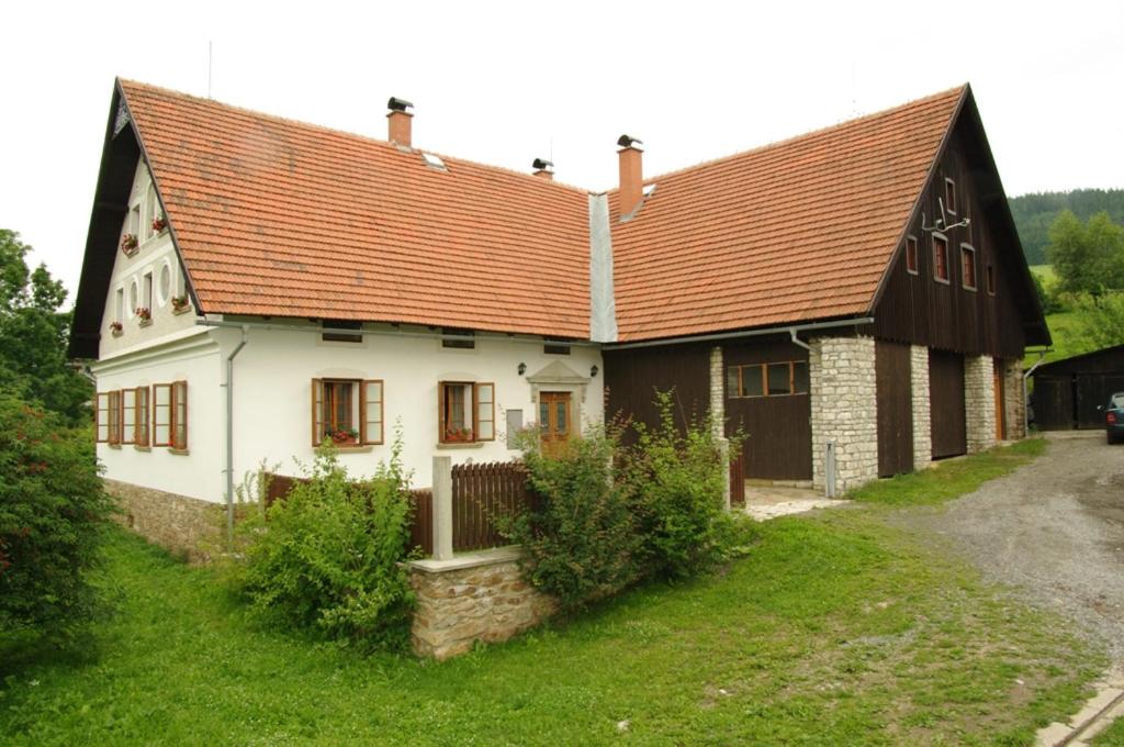 een groot wit huis met een bruin dak bij Apartmány Chalupa u Floriánka in Dolní Morava