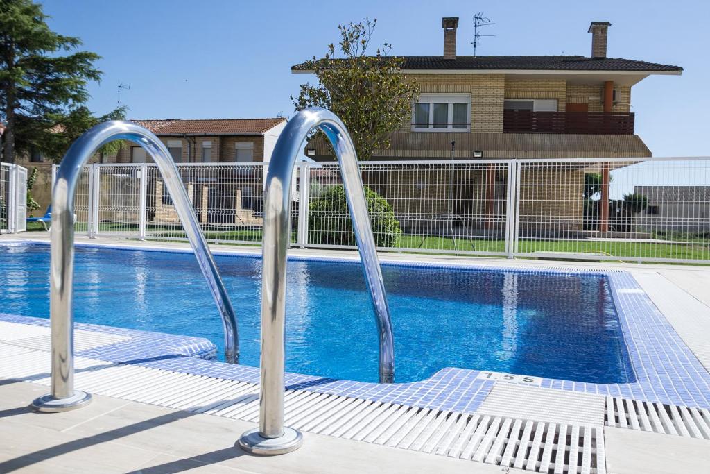 a swimming pool with two metal rails next to a pool at Villa Oasis de Bardenas & Piscina in Valtierra