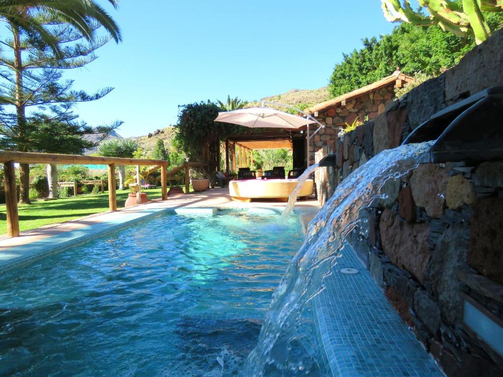 a swimming pool with a waterfall in a backyard at Cozy villa in San Bartolomé, 130 m², pool in San Bartolomé de Tirajana