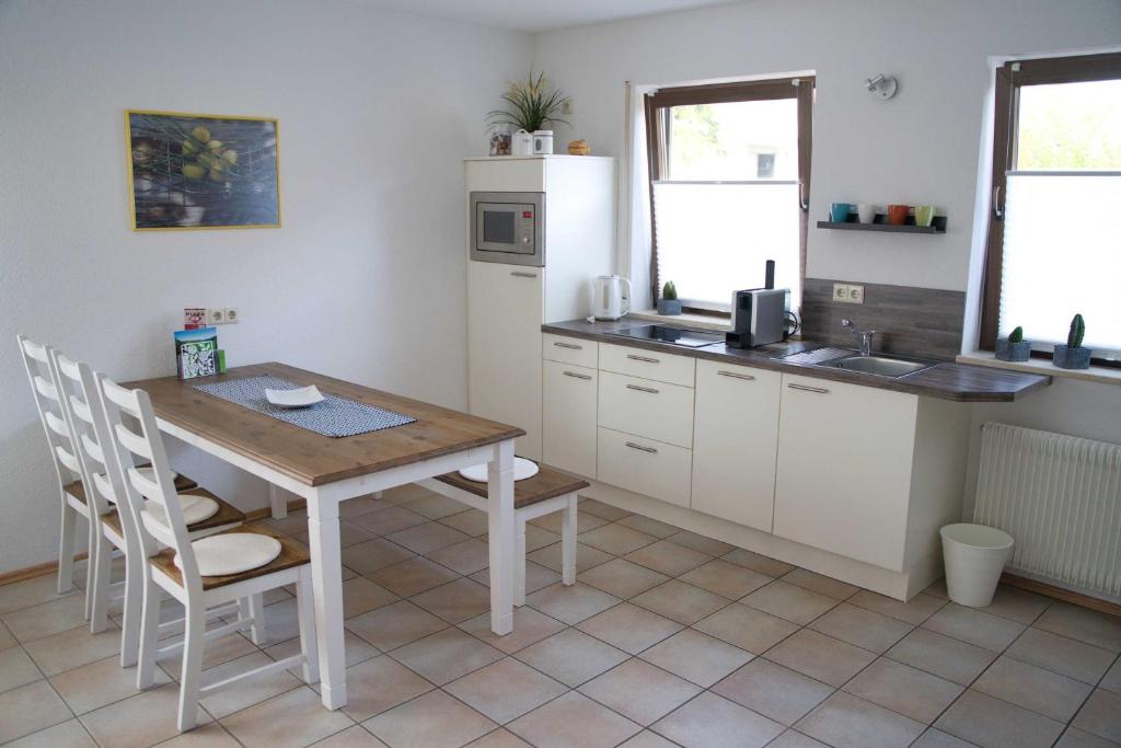 a kitchen with a wooden table and a table and chairs at Ferienwohnung naehe Freiburg FeWo in Holzhausen