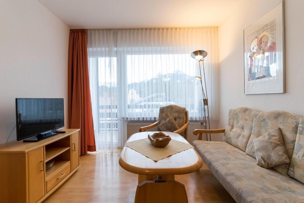 een woonkamer met een bank en een televisie bij Ferienwohnung M. Simbeck in Oberstdorf