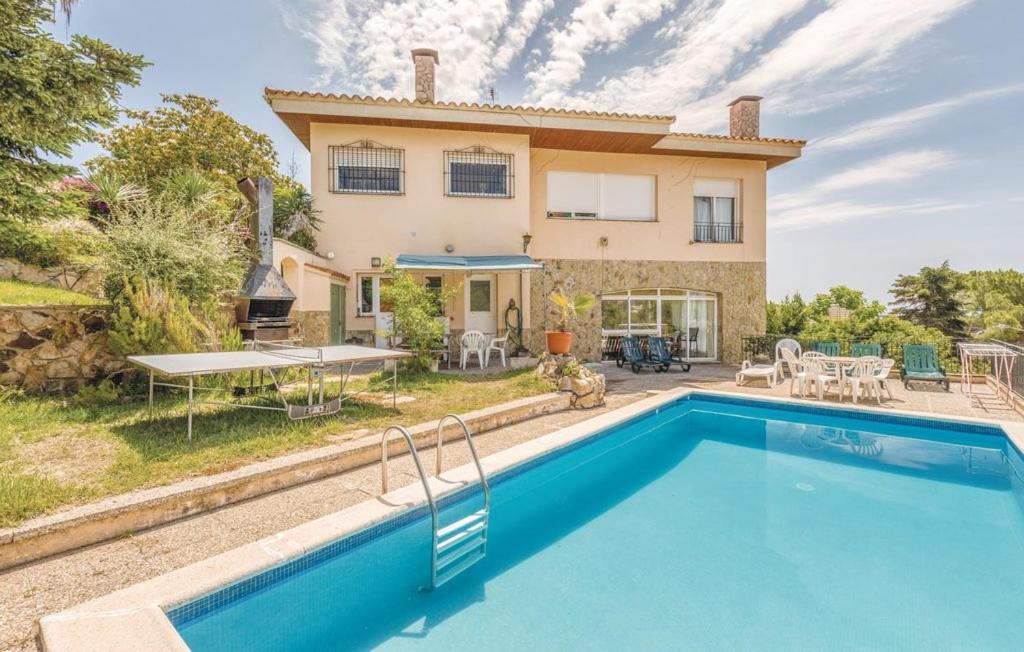 a villa with a swimming pool in front of a house at Villa Suria in Lloret de Mar