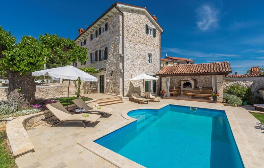 an outdoor swimming pool in front of a building at Beautiful Stone House - Villa Parentium with Private Pool in Dračevac