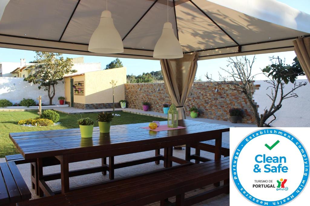 a wooden table with an umbrella on a patio at Casa da Monservia in Sintra