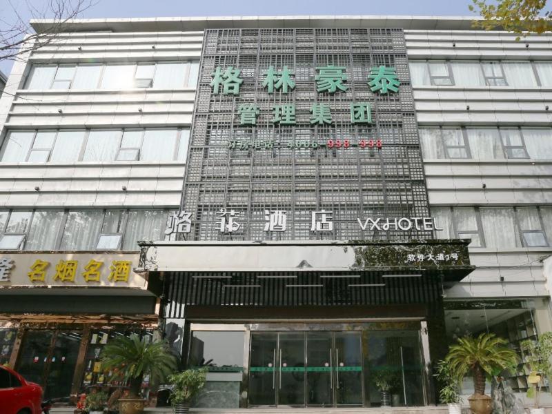 een gebouw met een bord aan de voorkant bij VX hotel Nanjing South Railway Station Daming Road Metro Station in Nanjing