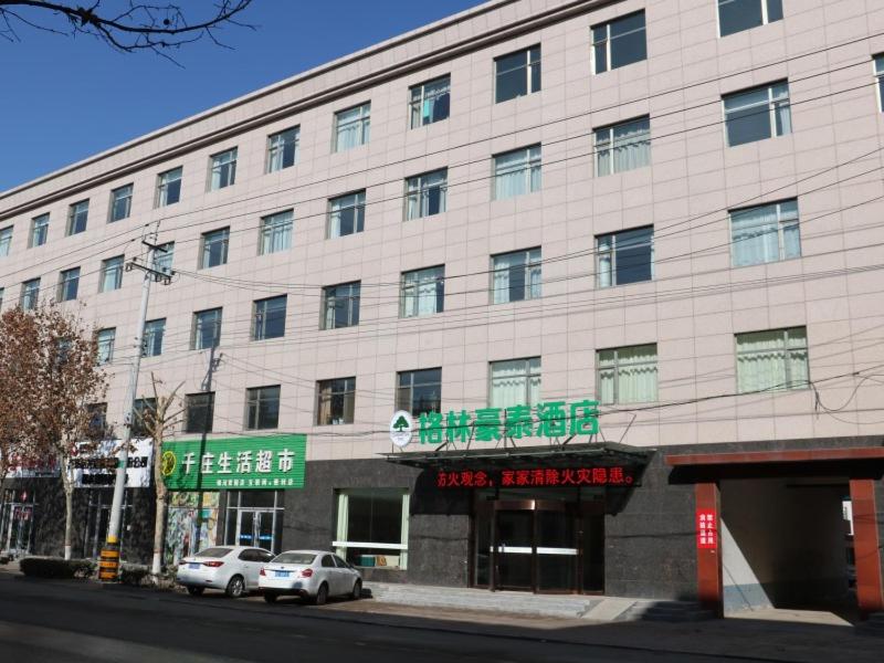 a large white building with cars parked in front of it at GreenTree Inn Hengshui Jingtai Avenue in Hengshui