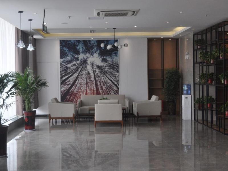 a lobby with chairs and a large painting on the wall at GreenTree Inn Shangqiu Zhecheng Shanghai Road in Shangqiu