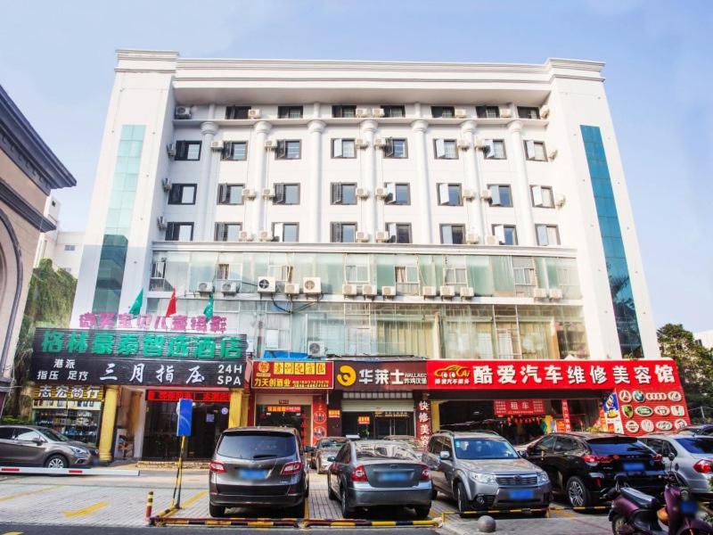 ein großes Gebäude mit davor geparkt in der Unterkunft GreenTree Inn Haikou Haixiu Middle Road in Haikou