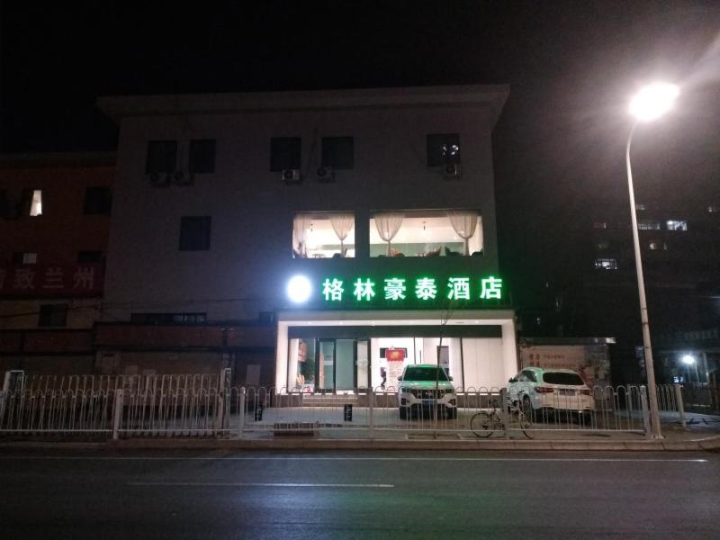 un edificio con una señal verde delante de él en GreenTree Inn Lanzhou Donghu Square Provincial People's Hospital en Lanzhou