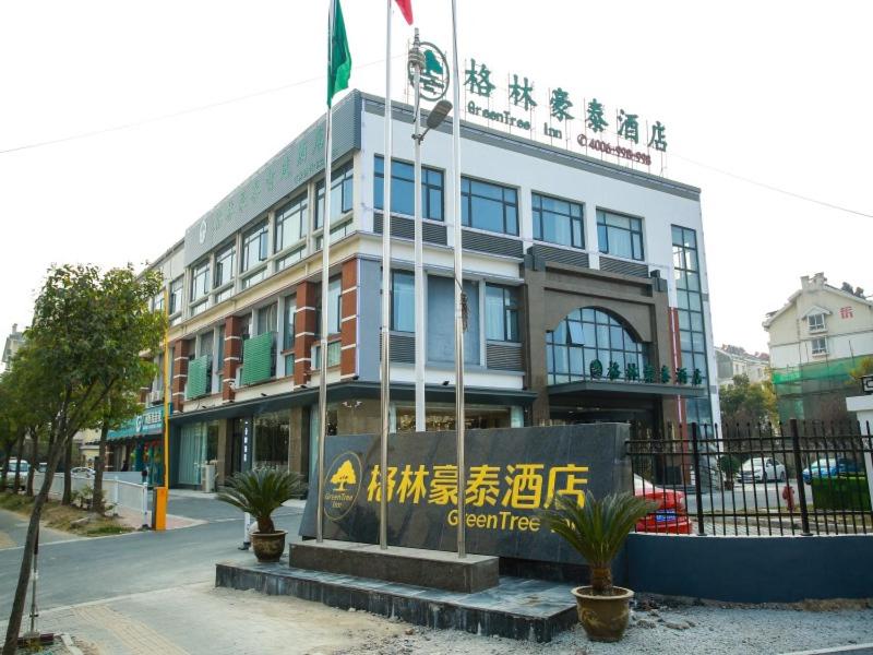 a building with a sign in front of it at GreenTree Inn Huai'an High-speed Railway Station University City East Yan'an Road in Huai'an